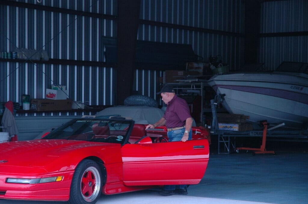 Inside of a steel garage with a red convertible car inside